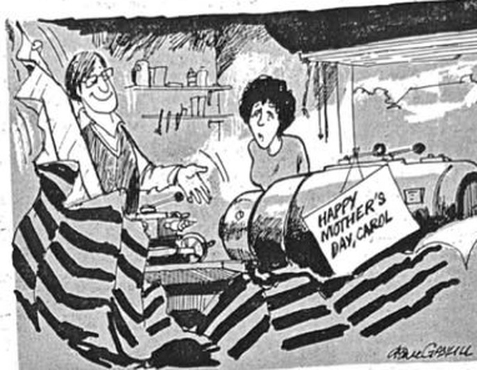 Cartoon accompanying the column: A husband whipping the dustsheet off a workshop lathe, a card propped against it lettered HAPPY MOTHER'S DAY, CAROL, and Carol's face falling behind him.